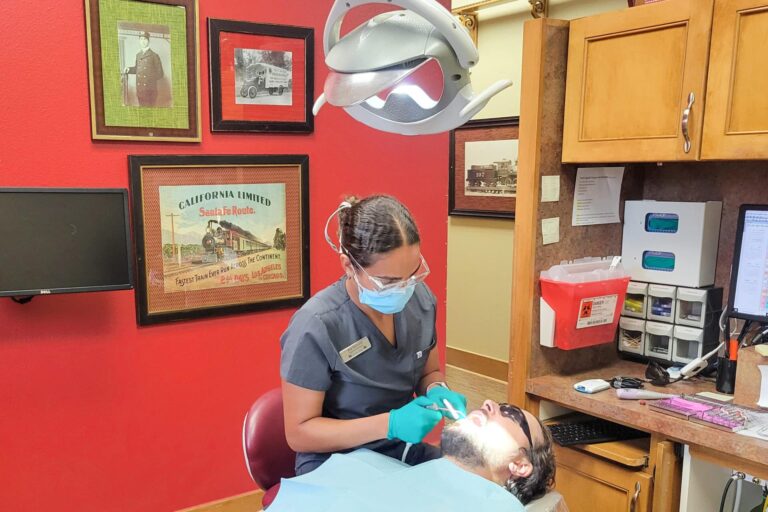 Dentist performing a dental cleaning on a patient at Dental Depot.