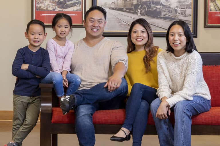 A family smiles as they wait patiently in dental depots lobby